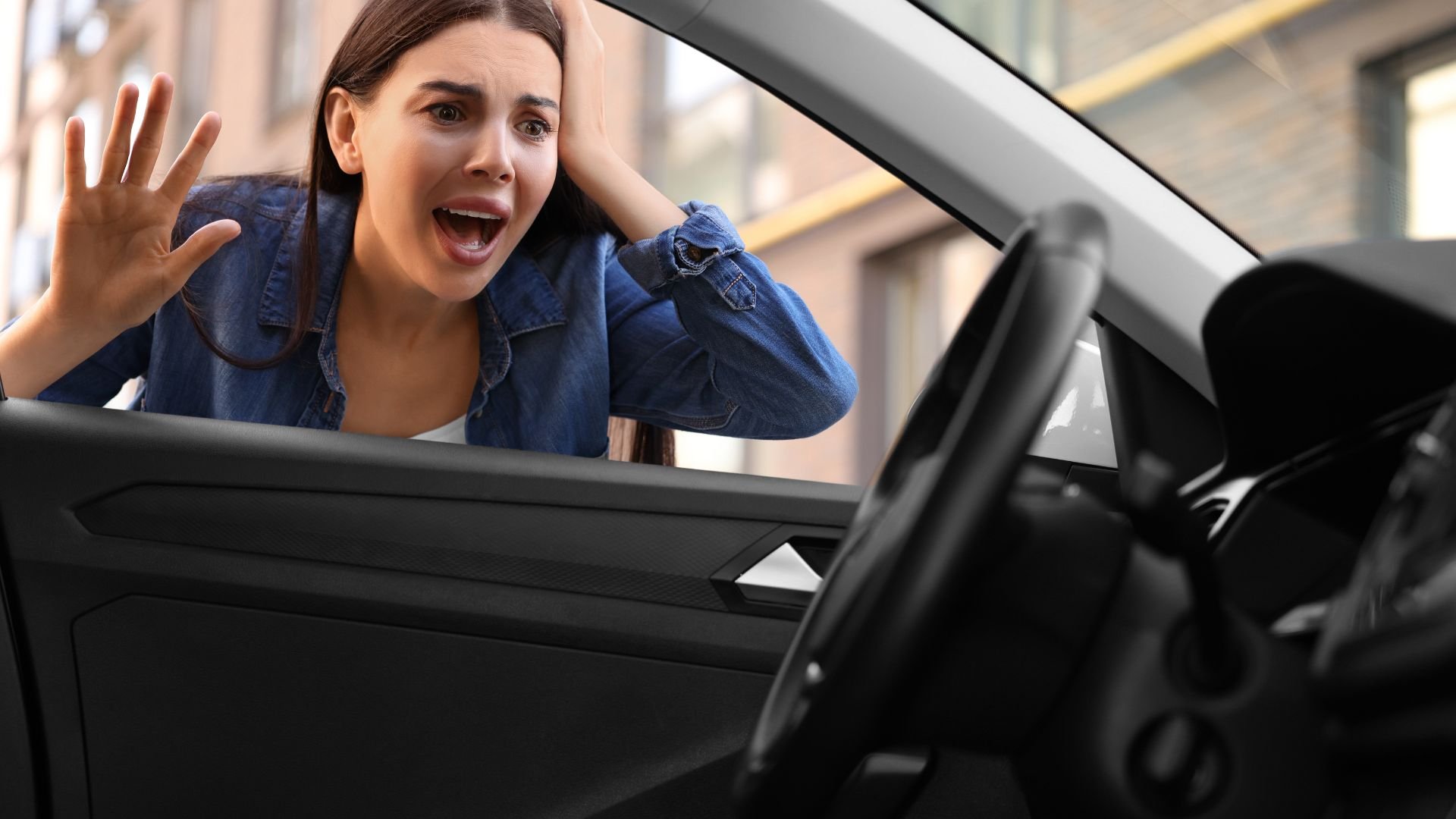 Frustrated woman reacting dramatically inside a car with open door