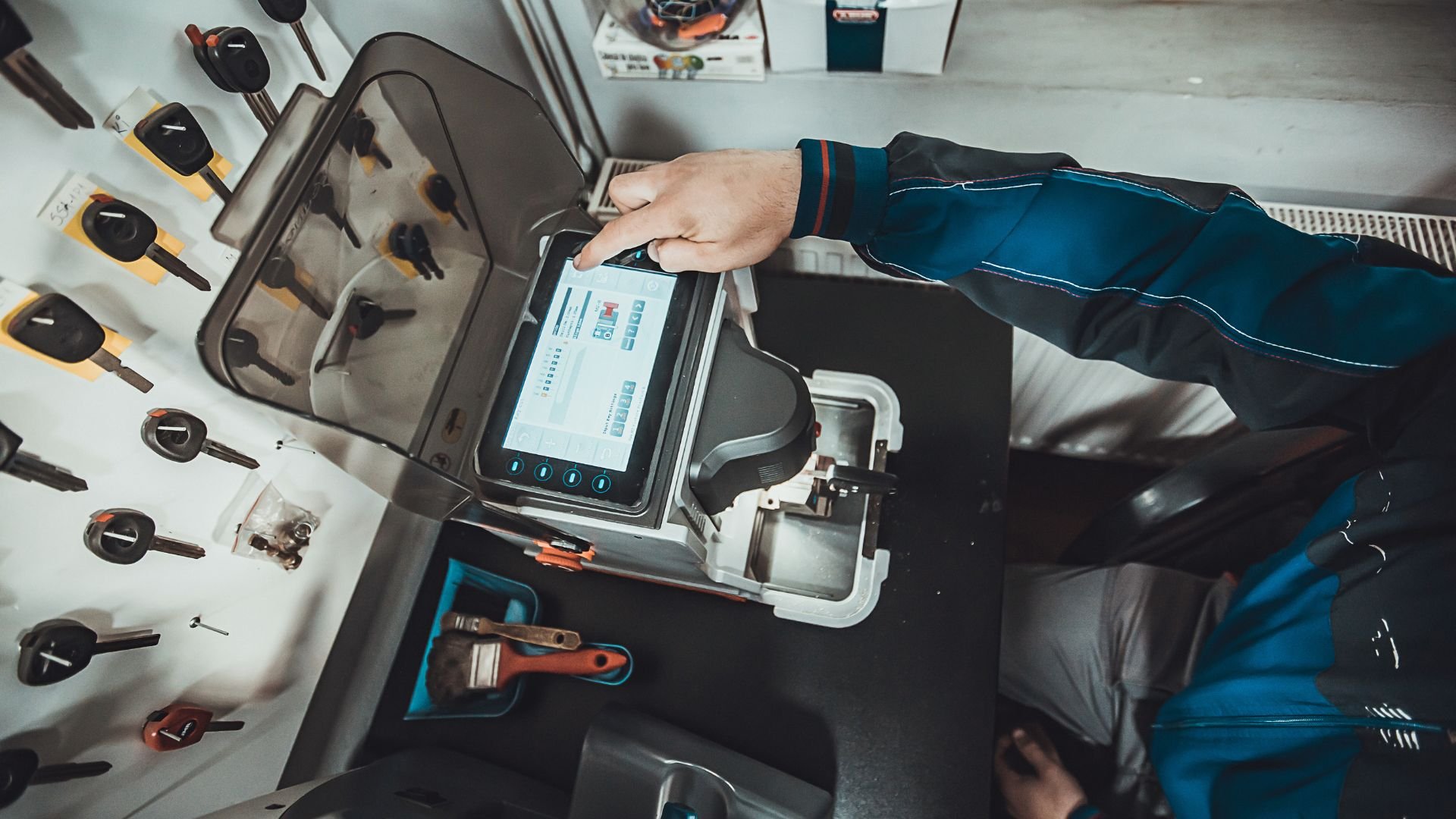 Technician using digital device among tools in vehicle diagnostic workspace