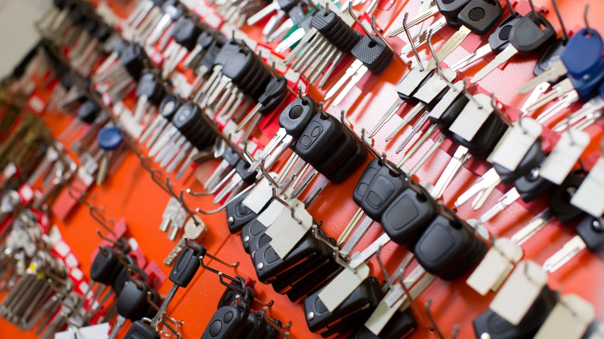 Electronic devices and remote controls hung on a red and white wall