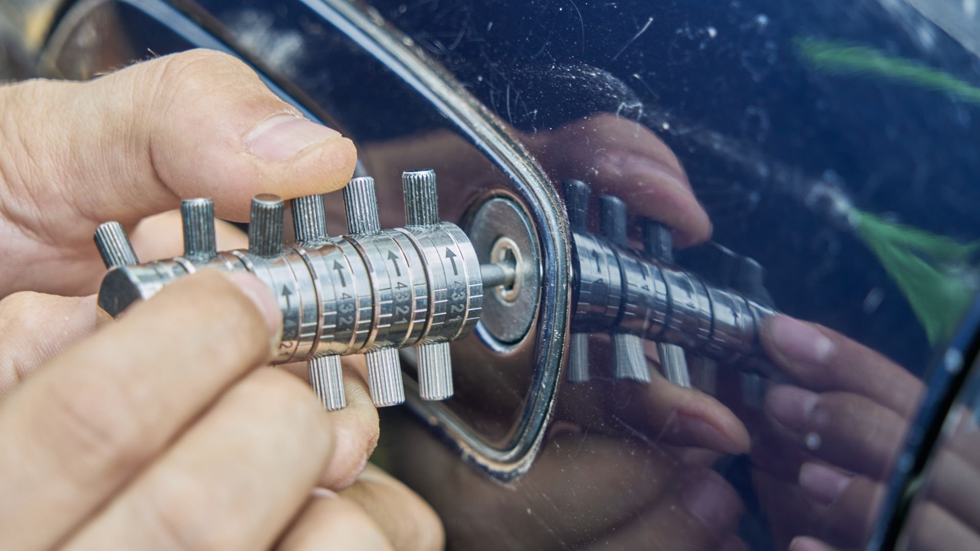 Close-up of hand adjusting a complex metallic mechanical calibration tool